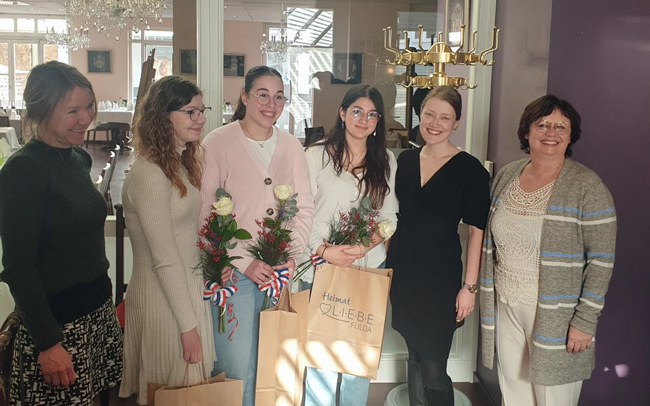 Gruppenbild von Lehrerinnen und Schülerinnen mit Blumen