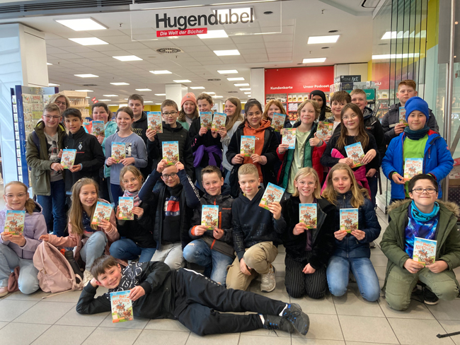 Schüler der Klasse G5d mit ihrem Buch in der Hand vor der Buchhandlung