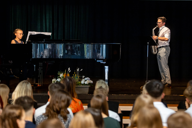 Schülerin am Klavier und Schüler mit Saxofon