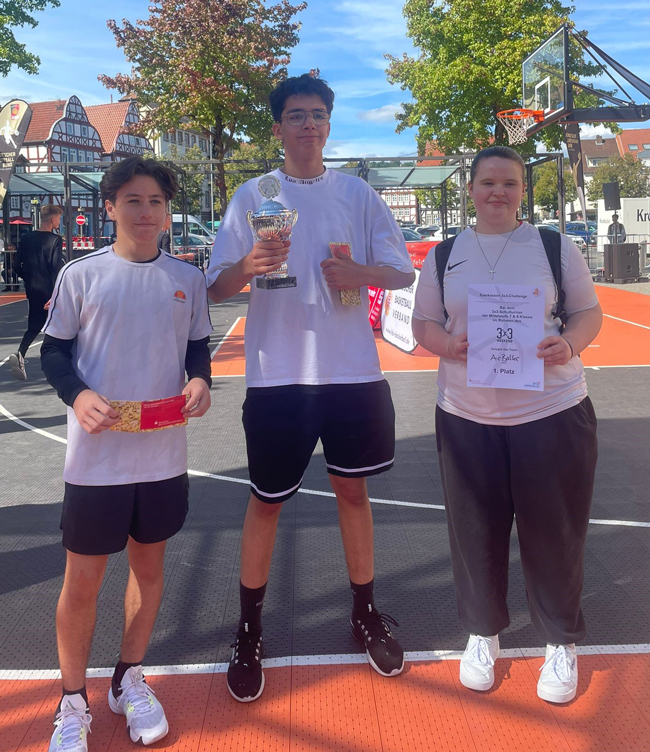 Zwei Jungen und ein Mädchen mit Pokal und Urkunde
