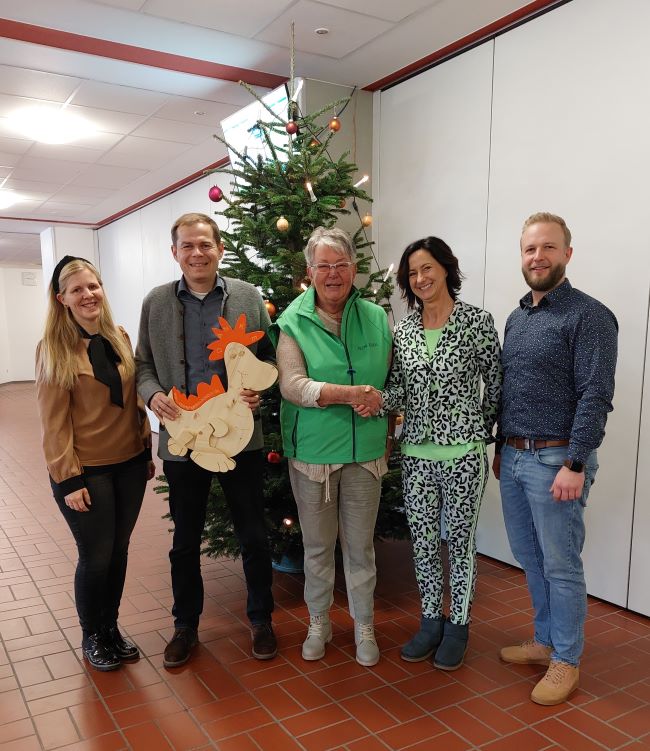 Schulleitung und Lehrer mit Frau Müller vor einem Weihnachtsbaum