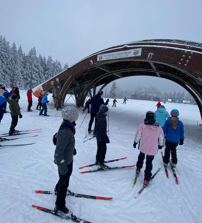 Schüler auf Skiern bei Schneefall auf der Piste