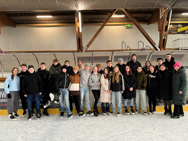 Gruppenbild auf Schlittschuhen in der Eishalle