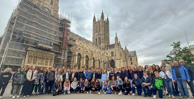 Gruppenbild Chorschüler und Begleiter vor imposanter Kirche in Canterbury
