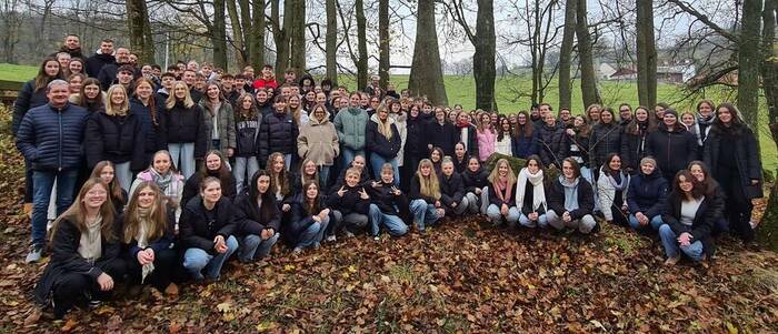 Gruppenbild der Chorschüler mit Leiter im Herbstwald