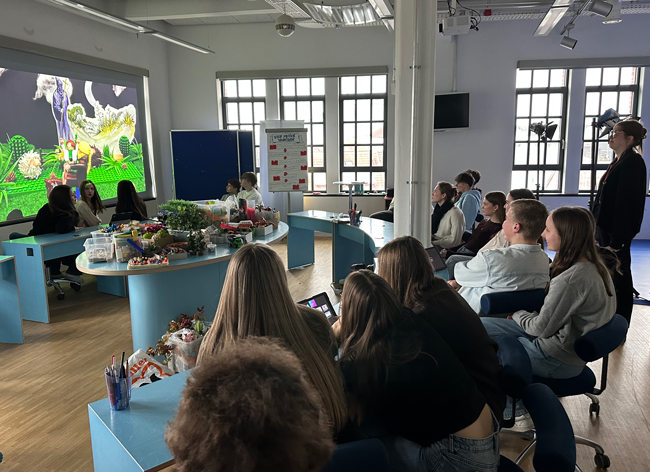 Schüler schauen auf eine Leinwand, auf der ein Minifilm präsentiert wird