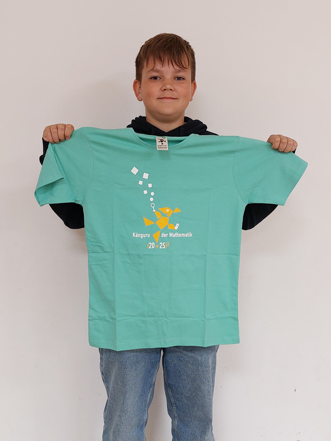 Schüler hält ein hellgrünes T-Shirt vor sich, auf dem das Logo des Känguru-Wettbewerbs abgedruckt ist