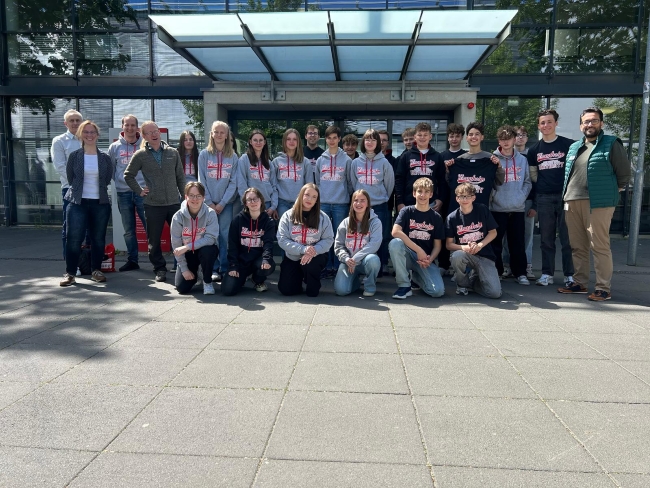 Gruppenfoto Schulklasse mit Professoren der Uni und gekleidet in Uni-Hoodies