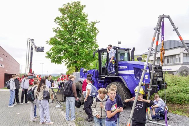 Schüler auf dem Schulhof vor großem Fahrzeug des THW