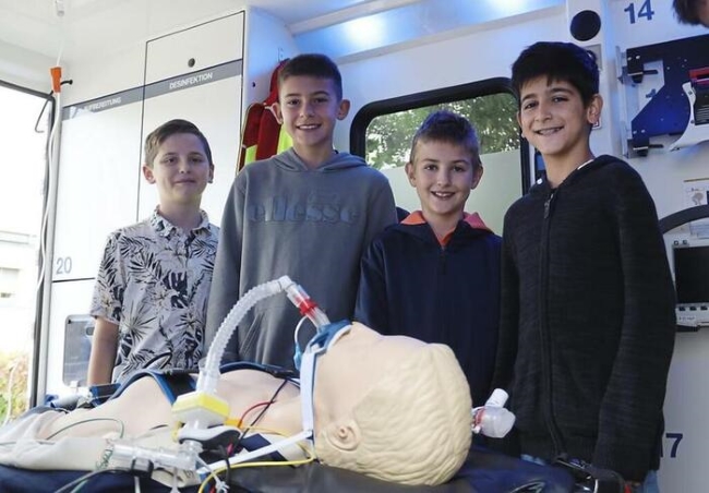 Vier Schüler stehen in einem Rettungswagen