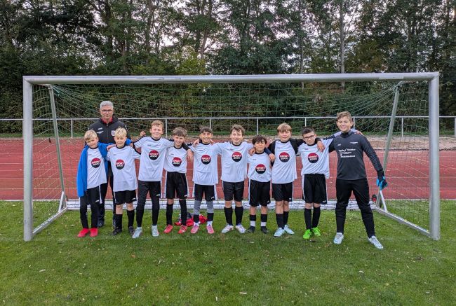 Gruppenbild der Fußballmannschaft mit Trainer im Tor