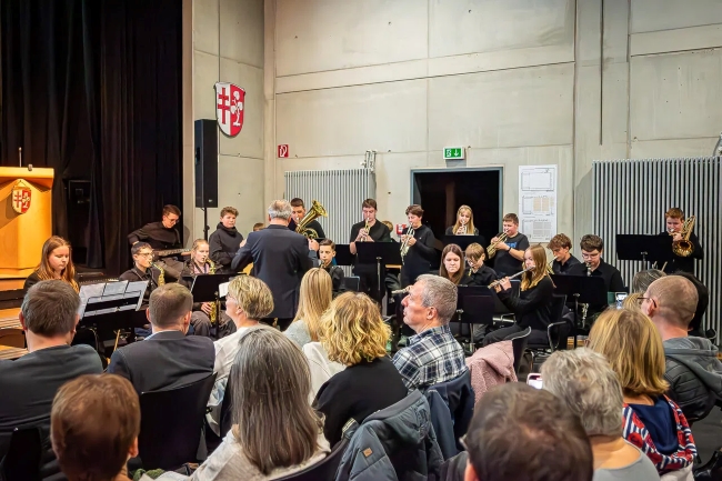 Publikum im Vordergrund schaut auf Schüler, die an Blasinstrumenten spielen