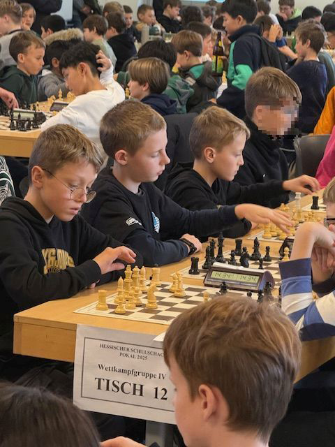 Schüler an Schachbrettern in einer großen Halle