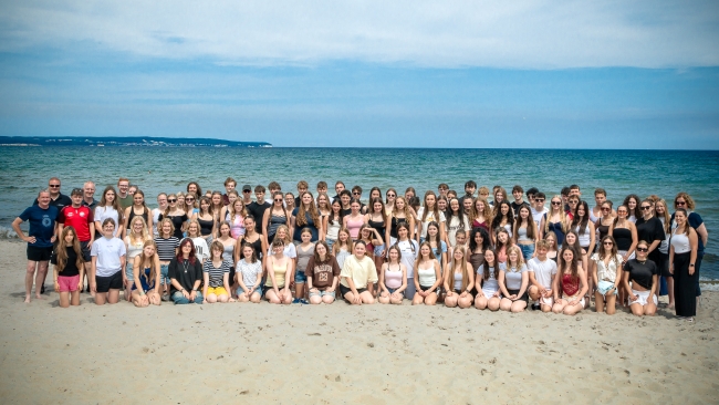 große Gruppe Schüler mit Lehrern am Strand