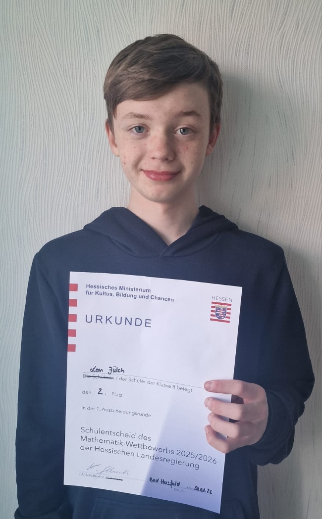 Portrait des Schülers Leon Jülch mit seiner Urkunde in der Hand